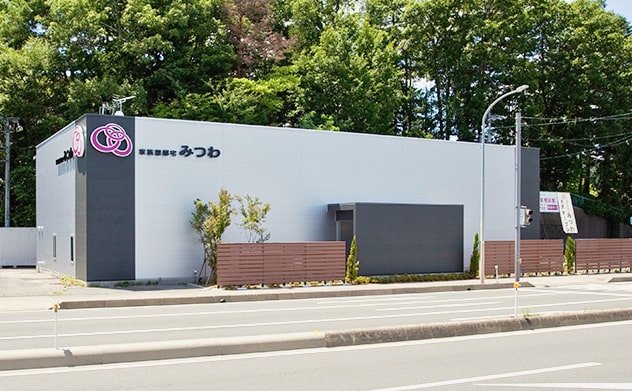 国道の向こう側から見た家族想邸宅みつわ臼田店の式場外観