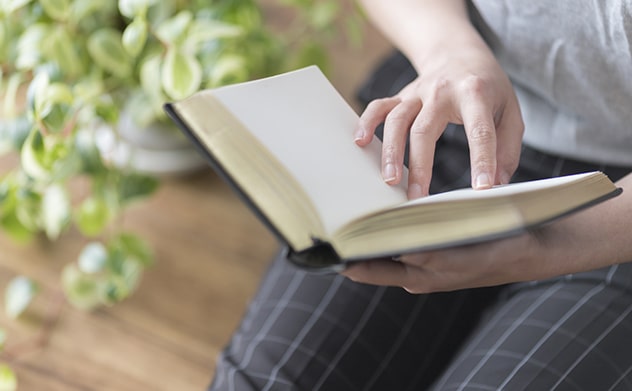 相続について専門書を調べる女性の手元